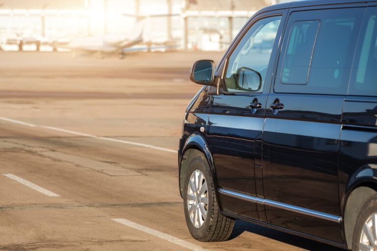 Black Mercedes Vito van parked at the airport terminal, captured from the left side.